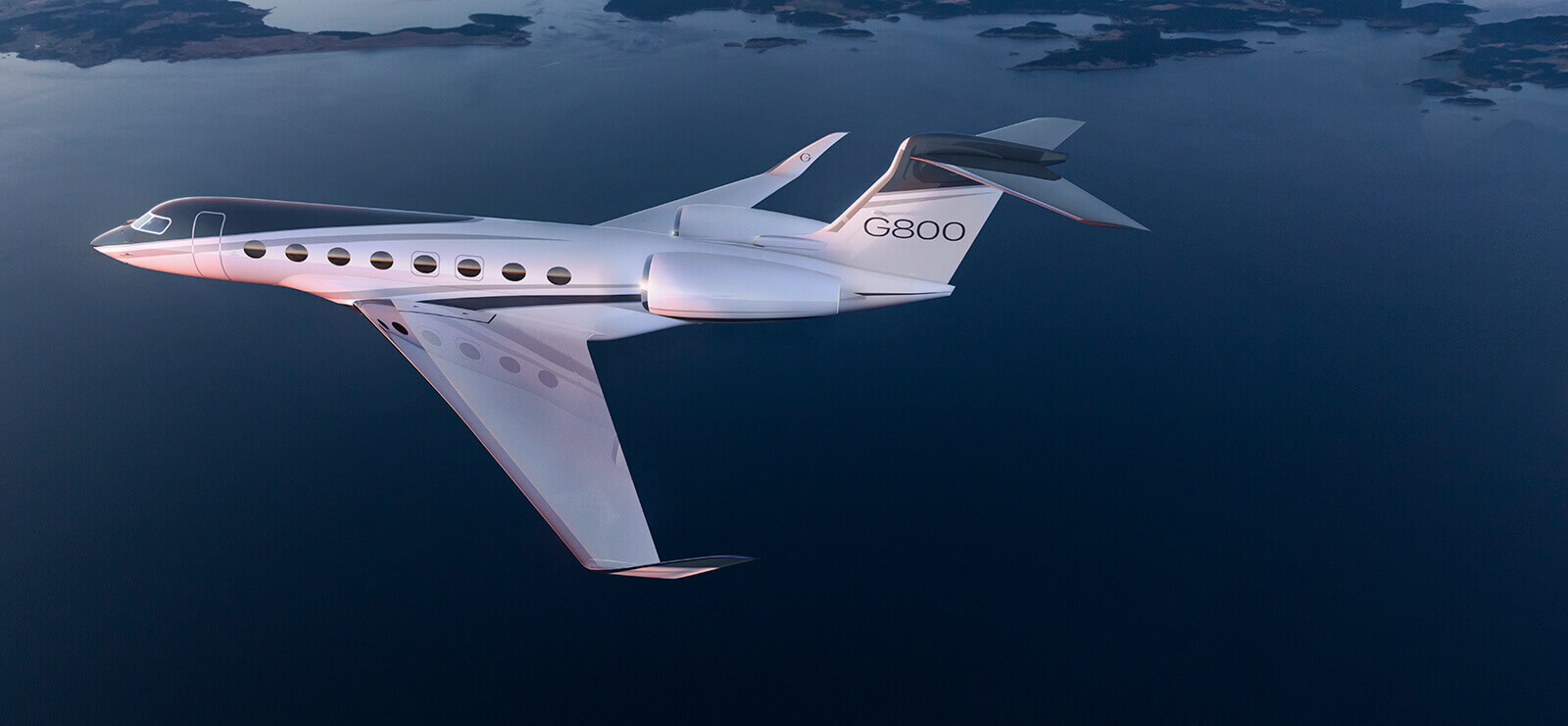 A Gulfstream G800 flies above a deep blue coastline dotted with small islands on the horizon.