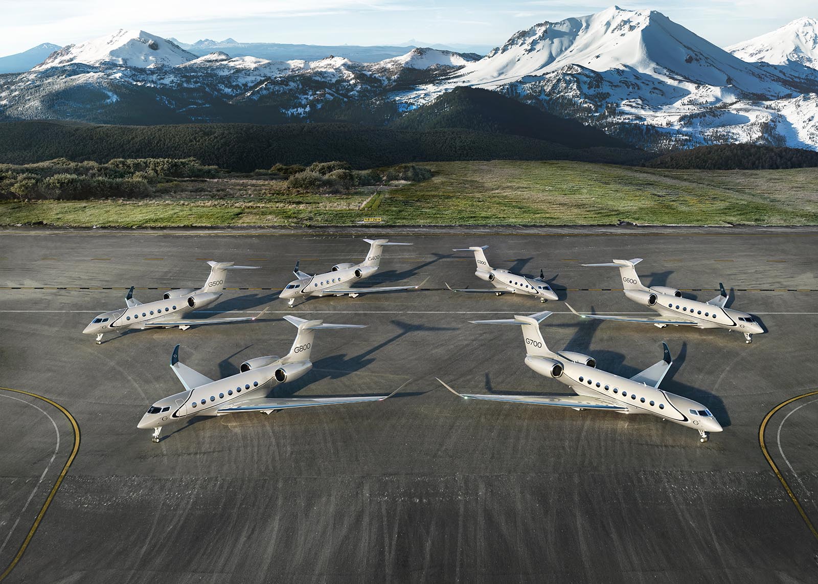 Seven Gulfstream aircraft on a runway with G800 and G400 at the front and the others in a quarter circle behind them
